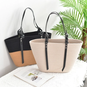 Detail of woven tote bag textures with faux leather handles and metal rivet fasteners