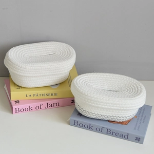 Detail of hand-woven cotton rope tissue box with grey wave pattern on decorative books