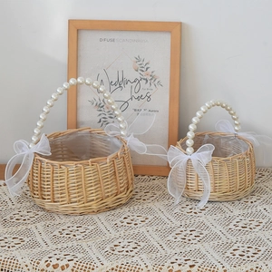 Handwoven willow baskets with large pearl handles and white organza ribbon detail