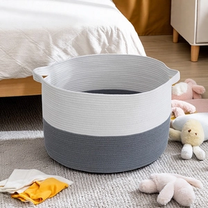 Macro view of woven cotton rope storage basket in two-tone white and grey with side handles