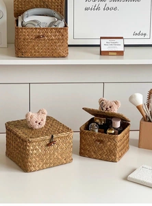 Detail of woven seagrass storage box with plush bear decor and wood button closure