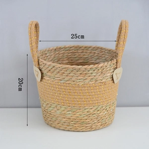 Detail of woven plant basket with gold metallic accents and heart-shaped leather patches