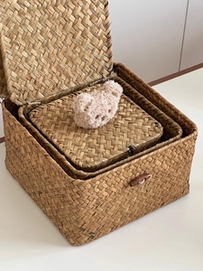Detail of woven seagrass storage baskets set with wooden buckle closure and lids