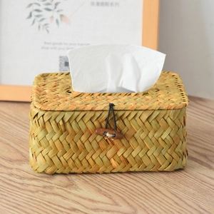 Detail showing natural handmade woven tissue box with wooden button closure on a table