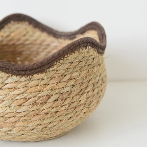 Macro detail of natural seagrass basket showing textured weaving and reinforced brown edge