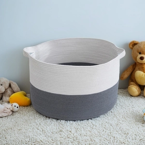 Detail of grey and white cotton rope storage basket featuring woven handles and soft texture