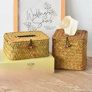 Detail of hand-woven straw tissue box with natural fiber texture and wooden toggle closure