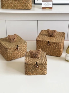Detail of three seagrass storage baskets with brown plush bear heads and button closure