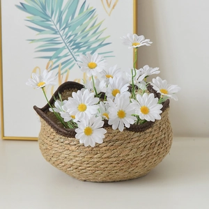 Detail of hand-woven seagrass basket with brown fabric trim and white daisies