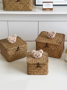 Detail of handwoven seagrass storage baskets with bear decor and wooden toggles