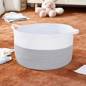 Close-up of woven cotton rope laundry basket with dual handles and gray-white patchwork
