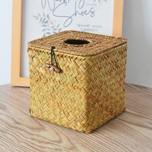 Detailed close-up of square woven straw tissue box with natural texture and olive wood buckle