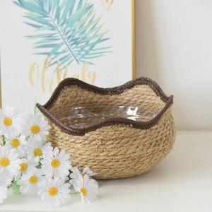 Detail view of woven plant basket with brown wavy edge and waterproof plastic lining