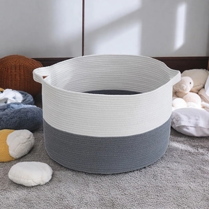 Detail of grey and white cotton rope storage basket in a warm home living room setting