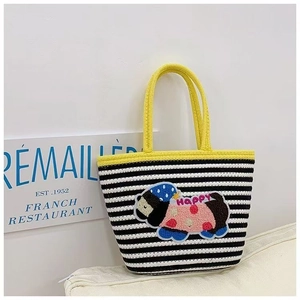 Close-up of woven tote bag featuring black and white stripes and a cartoon bear patch