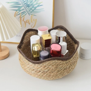 Detail of hand-woven straw storage basket with brown wavy edge holding cosmetics