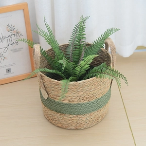 Detailed close-up of handmade straw planter basket with green stripes and dual handles