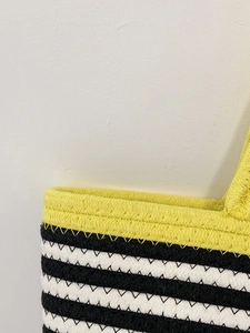 Close-up of the textured cotton rope weave with black, white, and yellow stripes on the tote bag