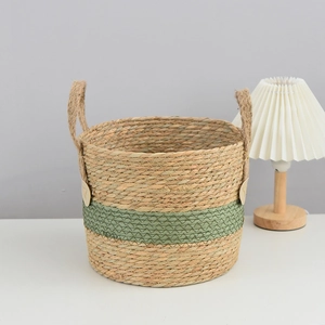 Close-up of handwoven seagrass storage basket with green stripe detail and rope handles