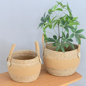 Detail of woven seagrass plant baskets with gold sequins and white leather handles