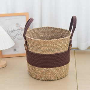 Close-up of woven seagrass basket with brown handles for home storage and plants
