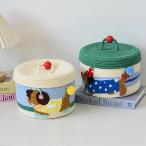 Detail view of woven cotton rope storage baskets with cute puppy embroidery and red handle