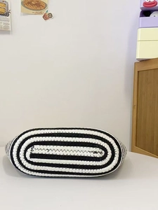 Close-up of black and white striped woven tote bag with premium textured finish