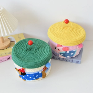 Detail of hand-woven cotton rope baskets with cute animal faces and colorful lids