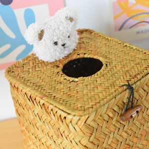 Detail of handwoven straw tissue box featuring a plush bear head and wooden button closure
