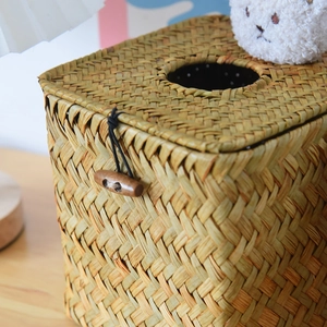 Close-up of handmade straw tissue box with wooden toggle button and natural texture