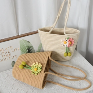 Dettaglio delle borse intrecciate con ciondoli a fiori in maglia 3D color crema e cammello