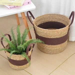 Detail view of woven plant baskets with sturdy fabric handles and two-tone texture