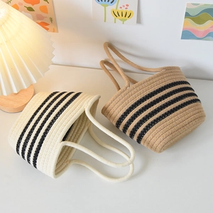 Détail de sacs fourre-tout tissés à rayures noires en tons crème et jute naturel