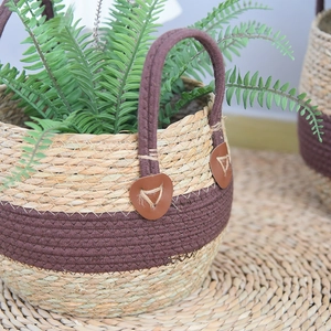 Close-up of seagrass plant basket with natural weave texture and brown leather handles