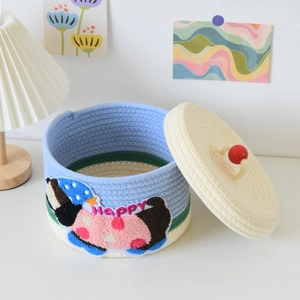 Detail of multi-color woven cotton rope storage basket with embroidered happy patch