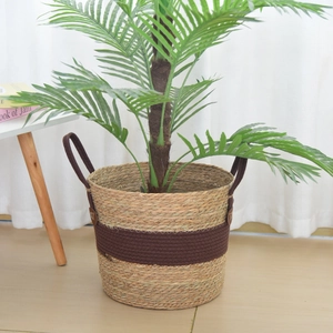 Close-up of woven seagrass plant basket with brown fabric band and rope handles