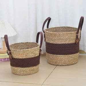 Detail of woven seagrass plant baskets with dual-tone design and leather accents