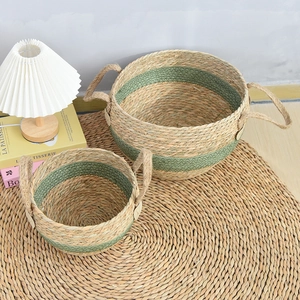 Detail of seagrass woven baskets with handles and green accents in a cozy home setting