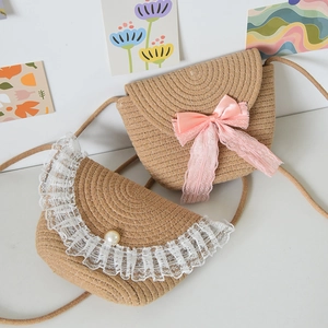 Detailed close-up of woven straw bags with pink lace bow and white pearl accents