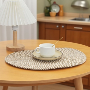 Nahaufnahme des nordischen geflochtenen ovalen Tischsets mit braun-weißem Spiralmuster