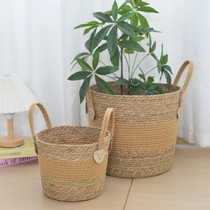 Detail of woven grass plant baskets with dual handles and golden sequin accents
