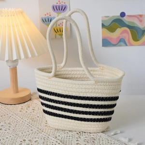 Détail du sac cabas tissé à rayures montrant la texture naturelle et le coton beige doux