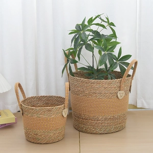 Detail of handwoven seagrass planters with leather handle accents and natural dual-tone texture