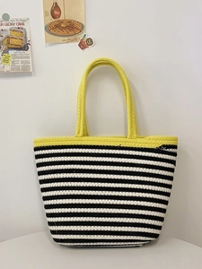 Detail view of a handwoven striped tote bag featuring yellow straps and textured cotton weave
