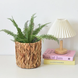 Macro shot of natural water hyacinth woven basket with green artificial fern plant