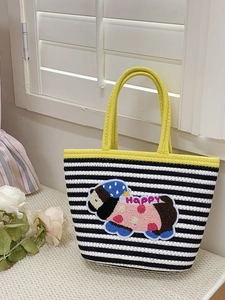 Detail view of woven striped tote bag with cute cartoon dog embroidery and yellow handles