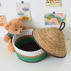Detail view of woven cotton rope basket with natural straw lid in home interior setting