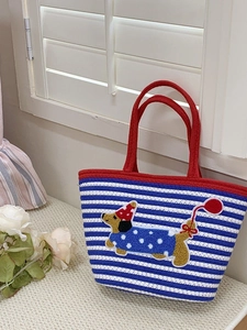 Detailed embroidery of a cute dachshund on a blue and white striped woven tote bag