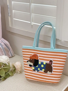 Close-up of woven tote bag with orange stripes and 3D cartoon puppy embroidery detail