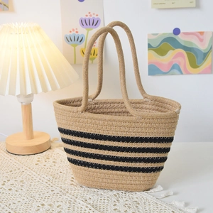 Détail du sac cabas tissé beige avec rayures noires parallèles et anses en corde souples